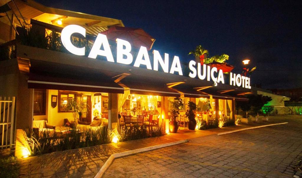 瓜拉图巴Hotel Cabana Suiça的一家餐厅,上面标有夜间读cabaania sukrita hotel酒店的标语