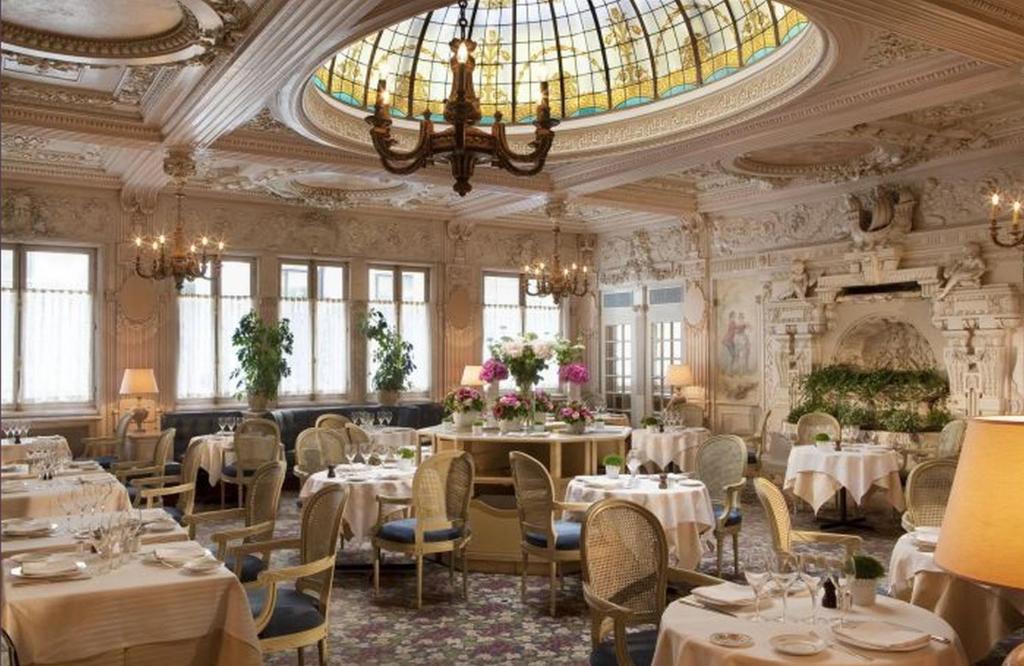 巴黎贝德福酒店的一间带桌椅和吊灯的用餐室