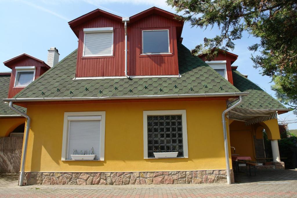 博加奇瓦伦蒂娜公寓的黄色和红色的房子,有绿色的屋顶