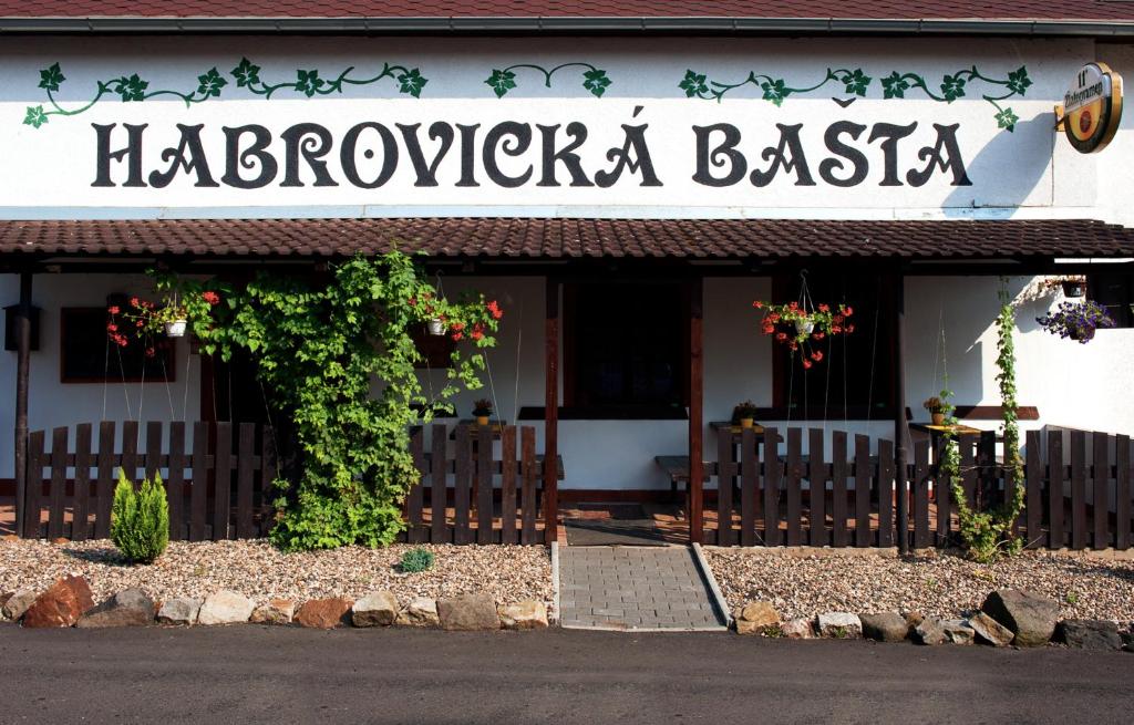 拉贝河畔乌斯季Penzion Habrovická Bašta的大楼前有标志的餐厅