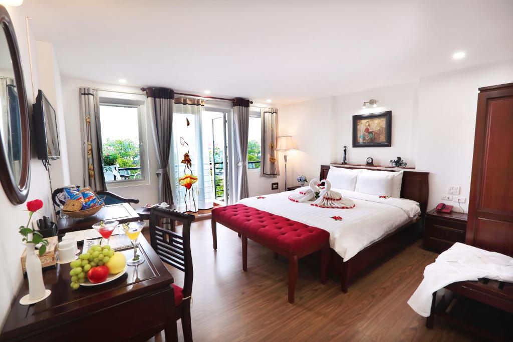 河内Hanoi Siva Luxury Hotel & Travel的一间卧室设有一张大床和一张红色长凳