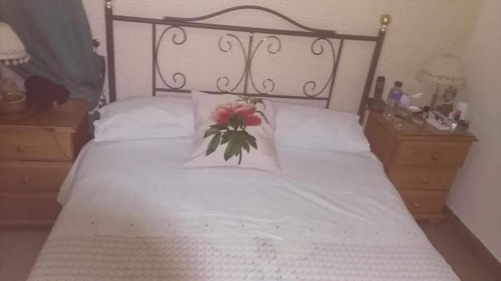 加尔达尔Casa Rural Anzo的卧室配有白色的床,床上有花