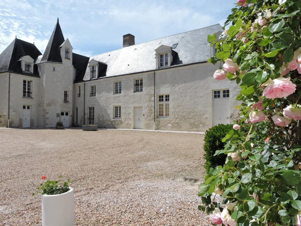 Mareuil-sur-CherLes Berges的一座白色的大城堡,前面有粉红色的玫瑰