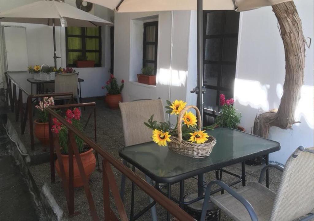 尼亚米卡尼奥纳Ariadne Studio的一张桌子,上面摆放着向日葵,还有椅子和遮阳伞