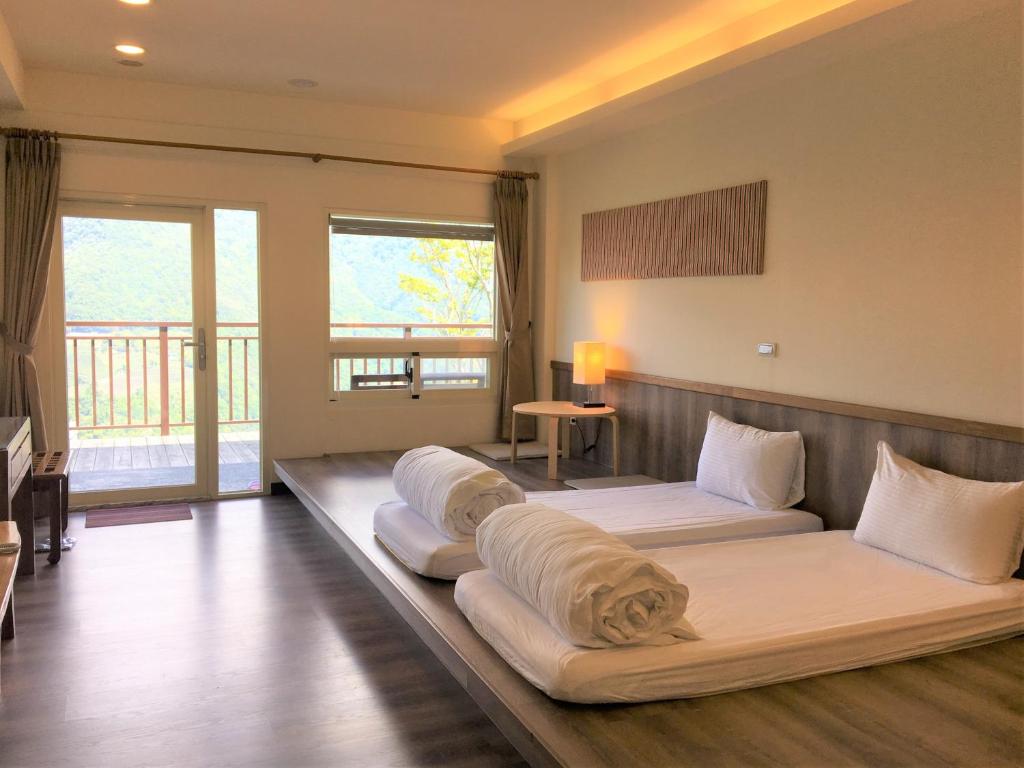 Hualing拉拉山云山房的一间位于地板上的客房,配有两张床和枕头