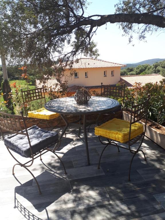 莫纳奇亚道勒内gite tomasini sabrina zirilla的桌子和两把椅子以及桌子和树