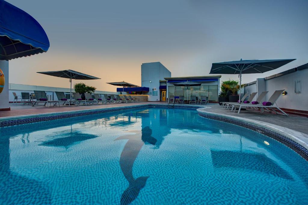 迪拜J5里马尔公寓式酒店的一个人站在游泳池里