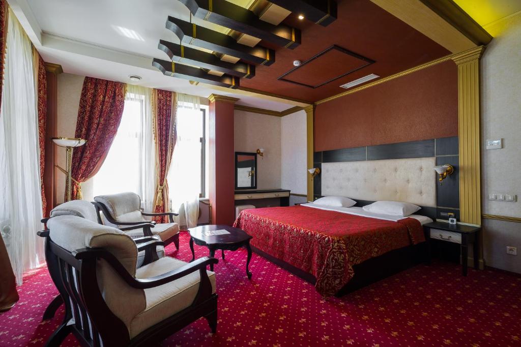克拉斯诺达尔特洛伊酒店的酒店客房,配有一张床和两把椅子