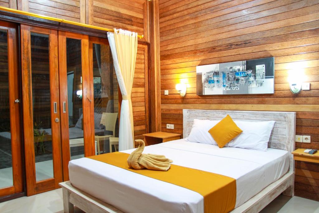 蓝梦岛特加尔酒店的一间卧室配有一张木墙床
