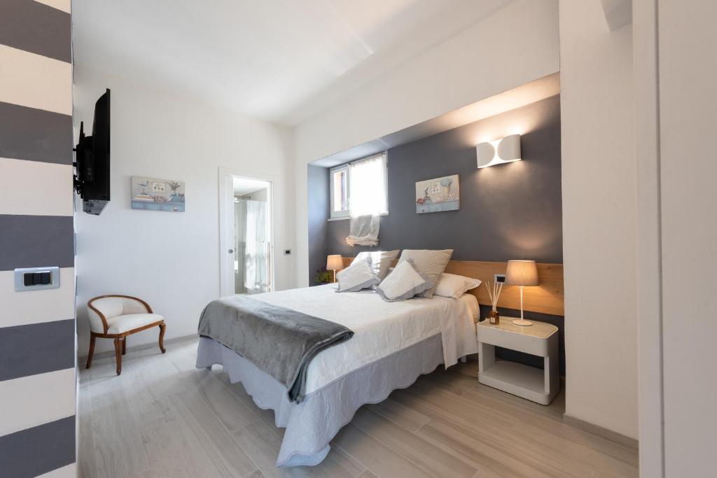 斯培西亚Relais Buonviaggio的一间卧室配有一张大床和一把椅子