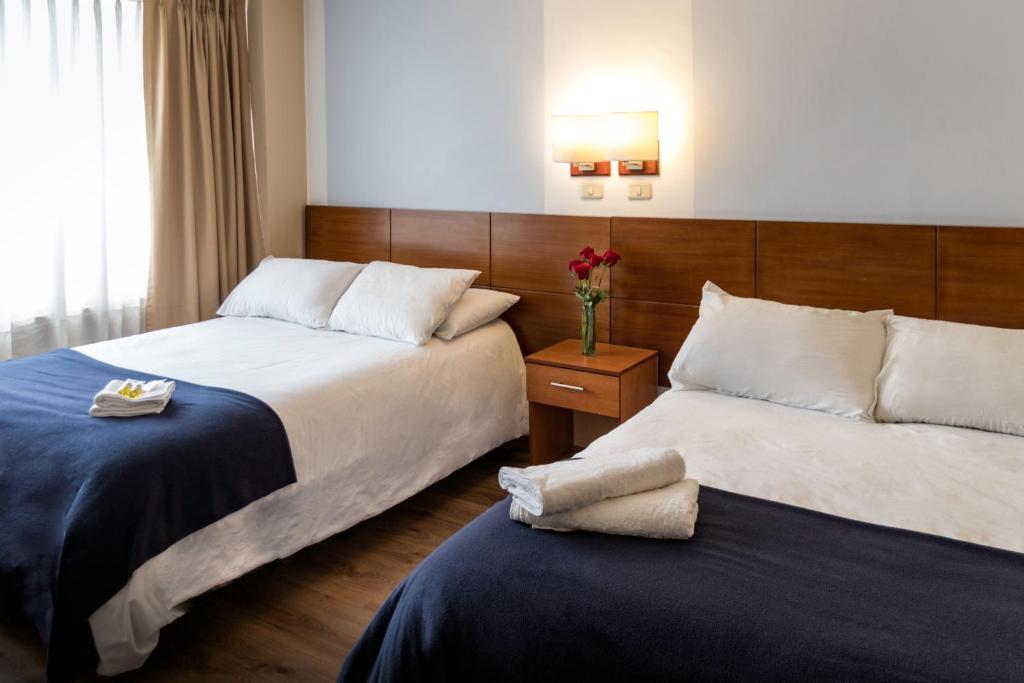 基多Filatelia Suites & Travel的酒店客房带两张床和花瓶