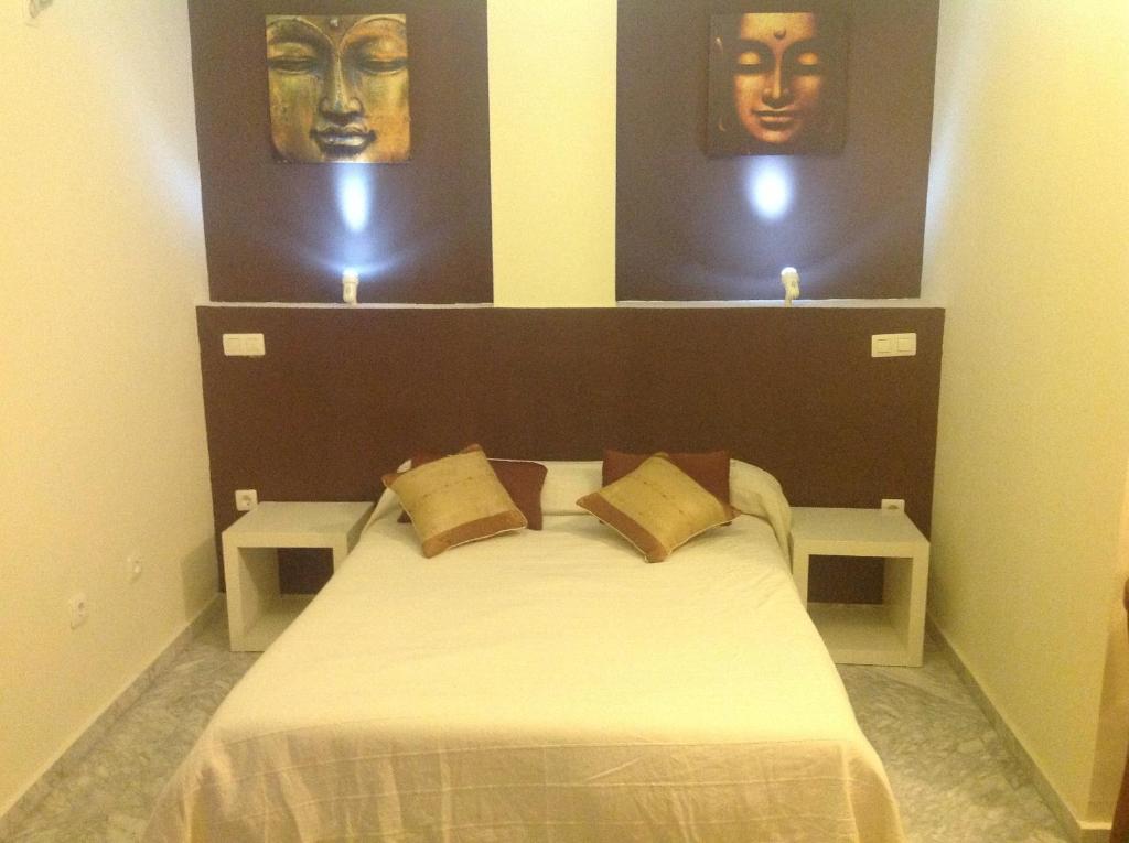 卡塞雷斯海王星旅馆 的卧室配有一张带两个面罩的床铺,墙上挂着两个面罩