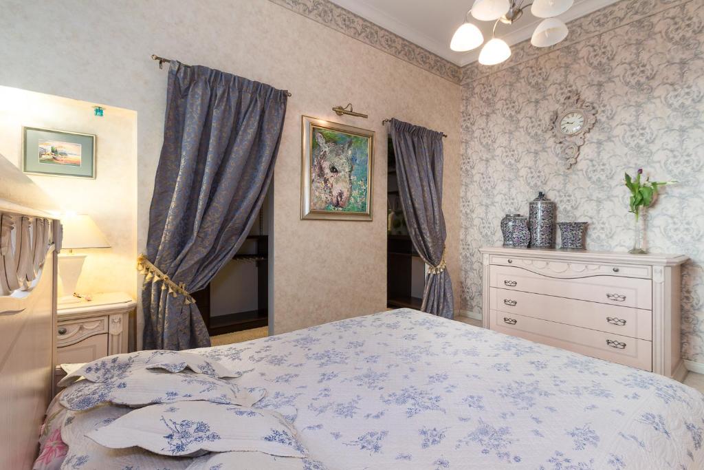 里加Royal的一间卧室配有一张床和一个梳妆台