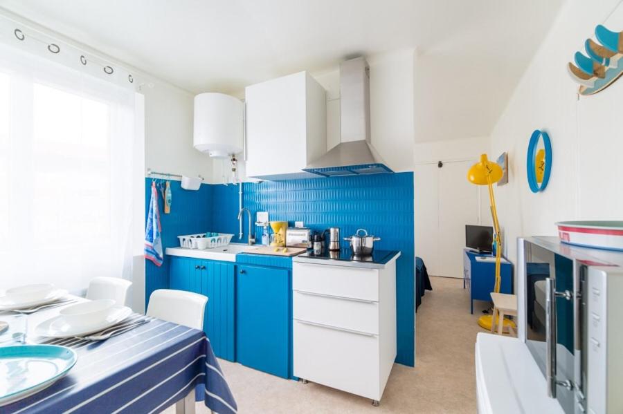 布科·莱斯白老城Le Studio Bleu de la gare的蓝色的厨房,配有白色橱柜和蓝色的墙壁