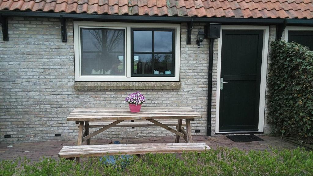比伦Uut in Thuus 21A的房屋前的野餐桌,上面有盆栽植物