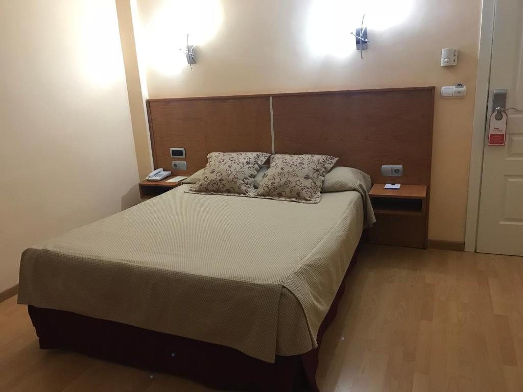 昆卡昆卡阿方索八世酒店的一间卧室配有一张带2个床头柜的大床