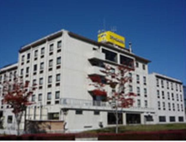 郡山郡山微笑酒店的上面有黄色标志的白色建筑