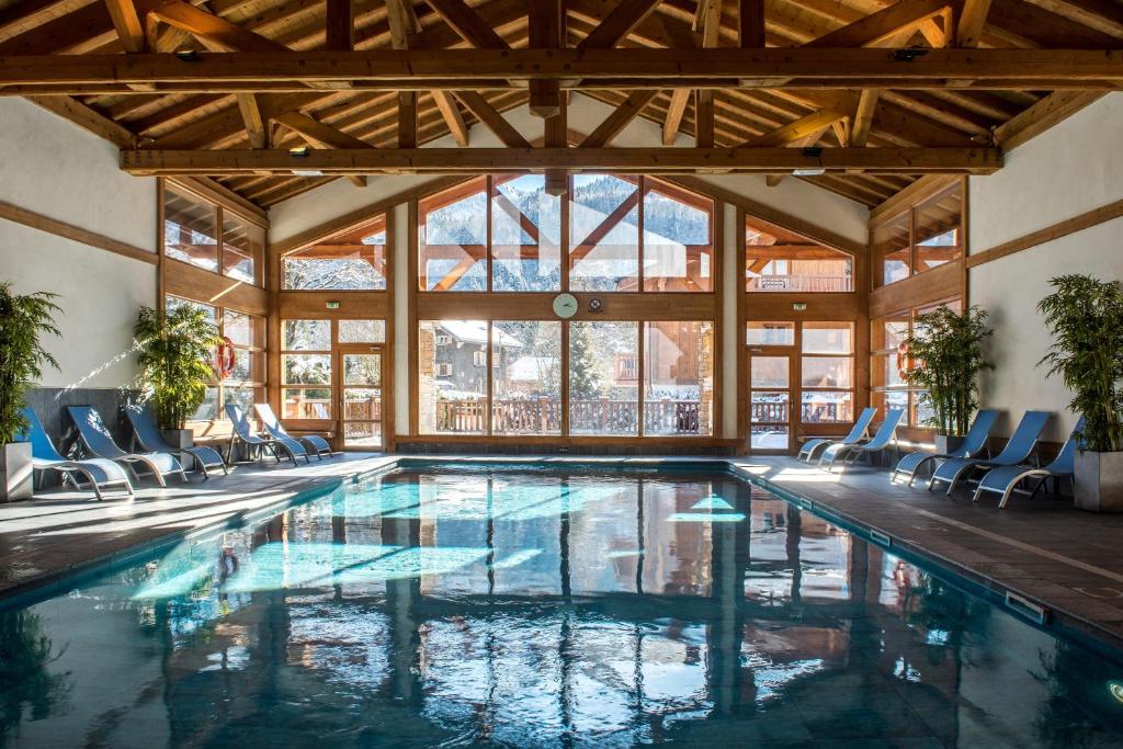 萨莫安斯拉赖因德培雷斯CGH公寓式酒店及Spa的一座带椅子和窗户的别墅内的游泳池