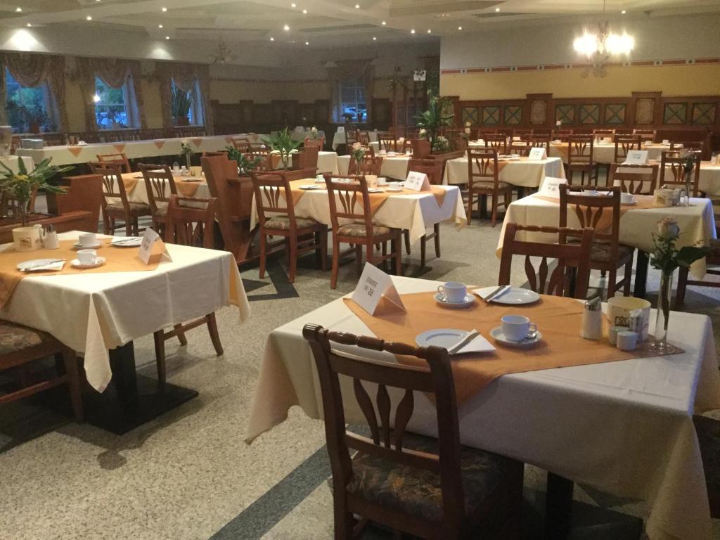 Oberpurkla西斯晒克拉德酒店的用餐室配有桌椅和白色的桌布