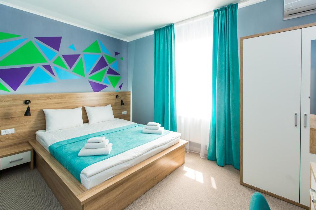 利沃夫Blum Hotel的一间卧室配有一张蓝色和绿色的墙壁。