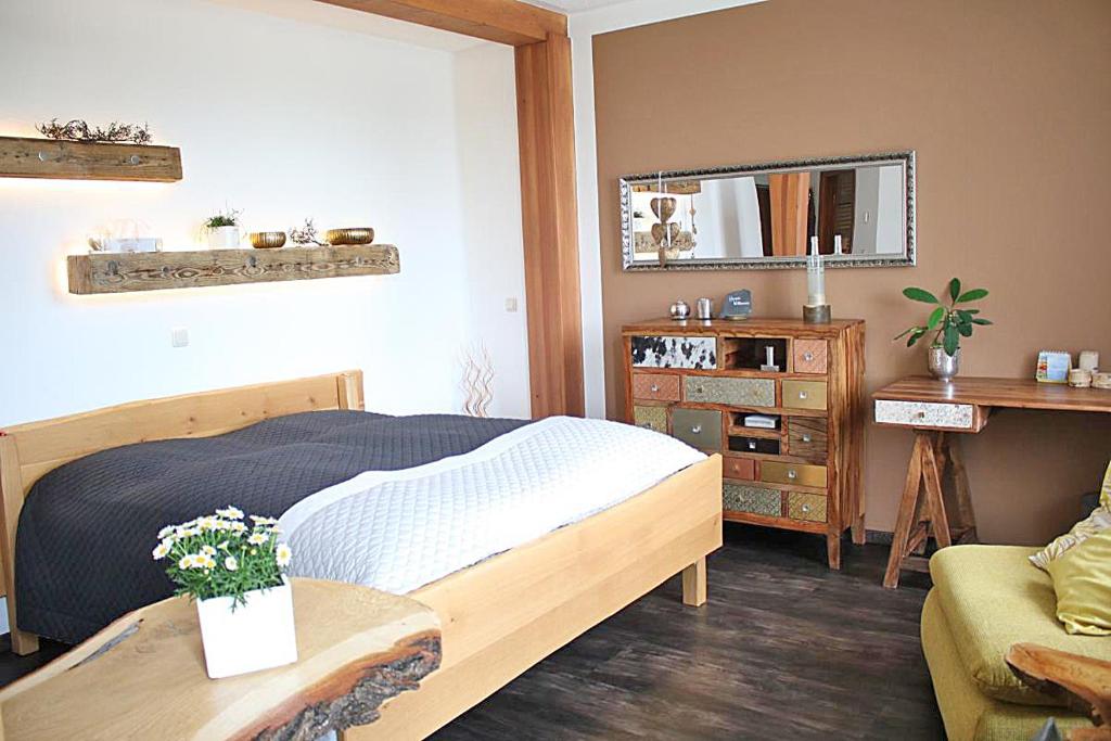 波尔Ehem. Sächsisch-Bayrischer Hof的一间卧室配有一张床、一张桌子和一面镜子