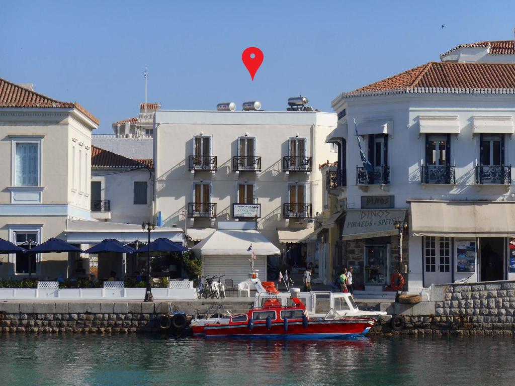 斯派赛斯Alexandris Hotel的船在水中,在建筑物前