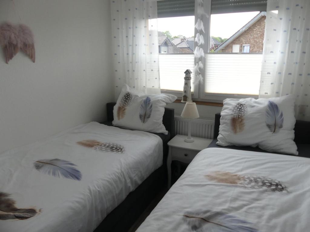 海因斯贝格Ferienwohnung Anke - Apartment 5d的一间卧室设有两张带白色床单的床和窗户。