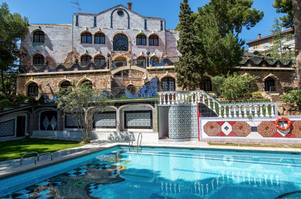 NáqueraApartamentos Gaudi Style的大楼前带游泳池的房子