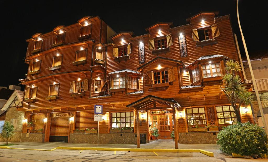 马德普拉塔西雷纳斯酒店的一座大型木制建筑,晚上有很多窗户