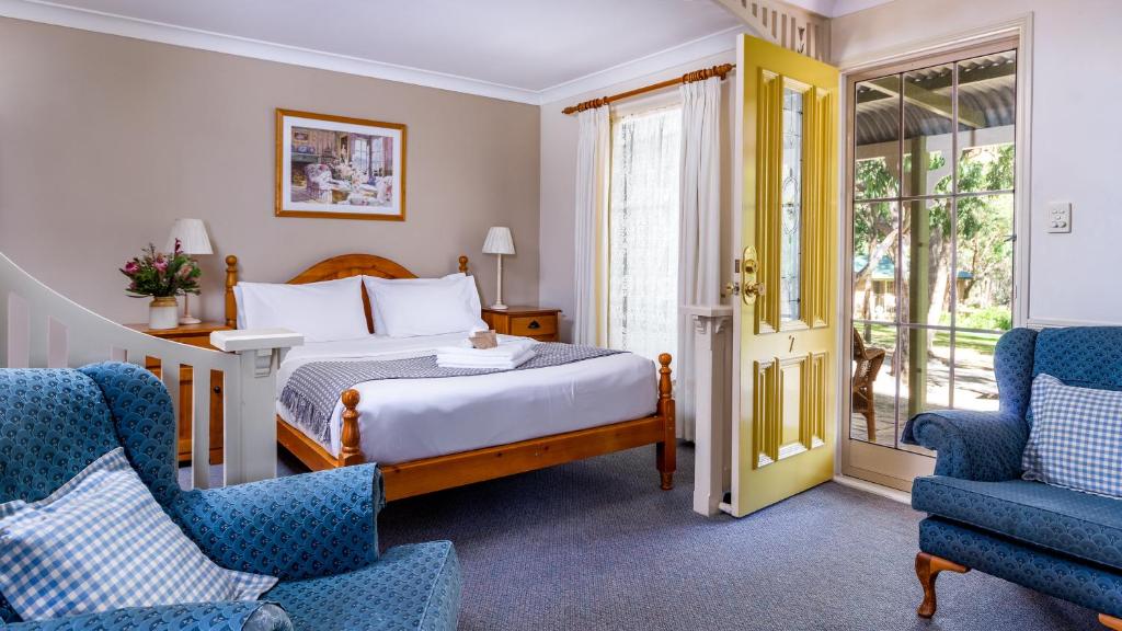 史丹霍普金银花山林小屋的酒店客房,配有一张床和两把椅子