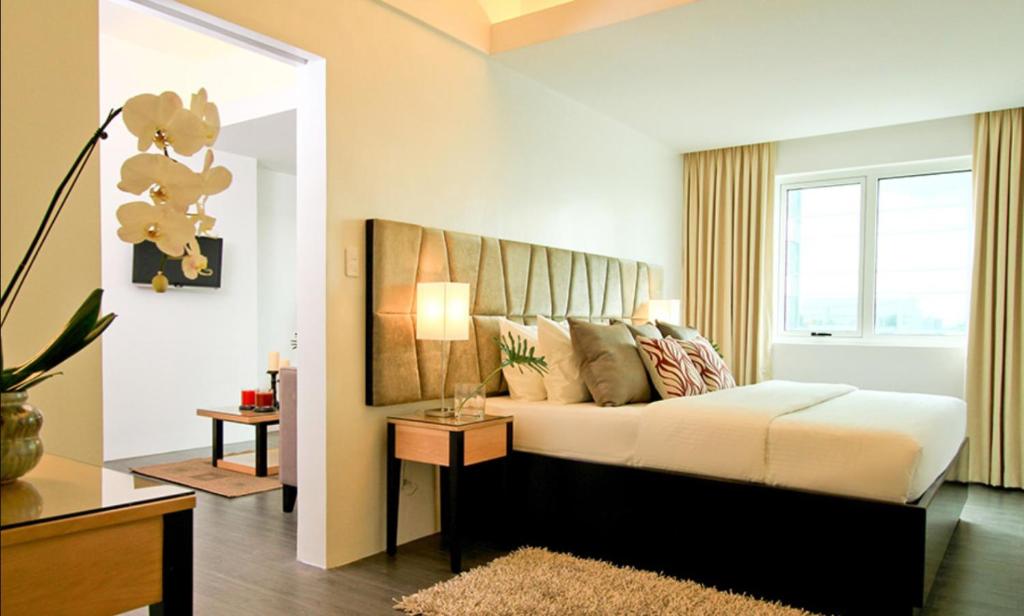 马尼拉Privato Ortigas的一间卧室设有一张大床和一个窗户。