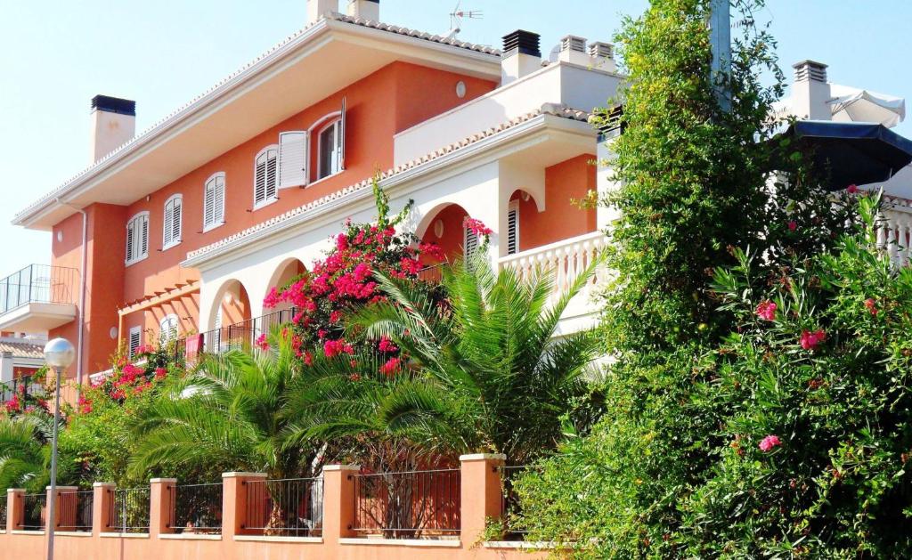 萨贡托Apartamentos Concha del Mar的一座橙色和白色的房子,前面有鲜花