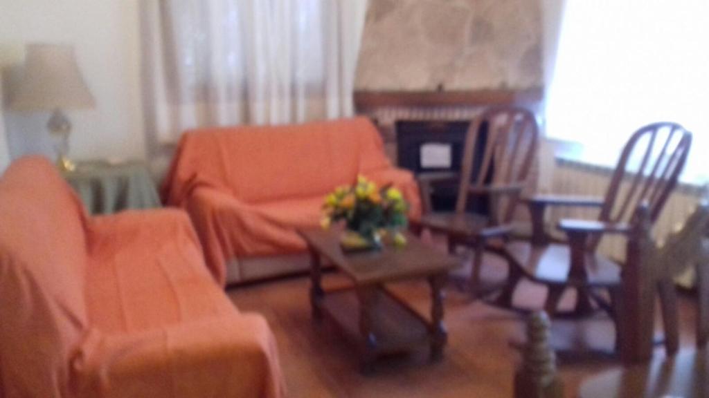 El HornilloCasa Rural del Río Tejos的客厅配有橙色沙发和桌子