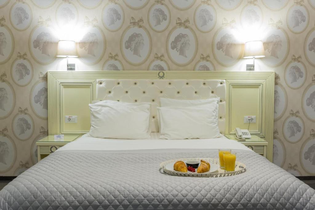 布加勒斯特Vila Cornelia的一间酒店客房,配有一张床铺,上面放着一个食物托盘