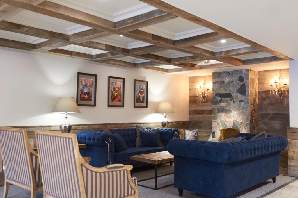 华沙欧别克特侯特拉斯基帕特隆酒店的客厅设有蓝色的沙发和壁炉
