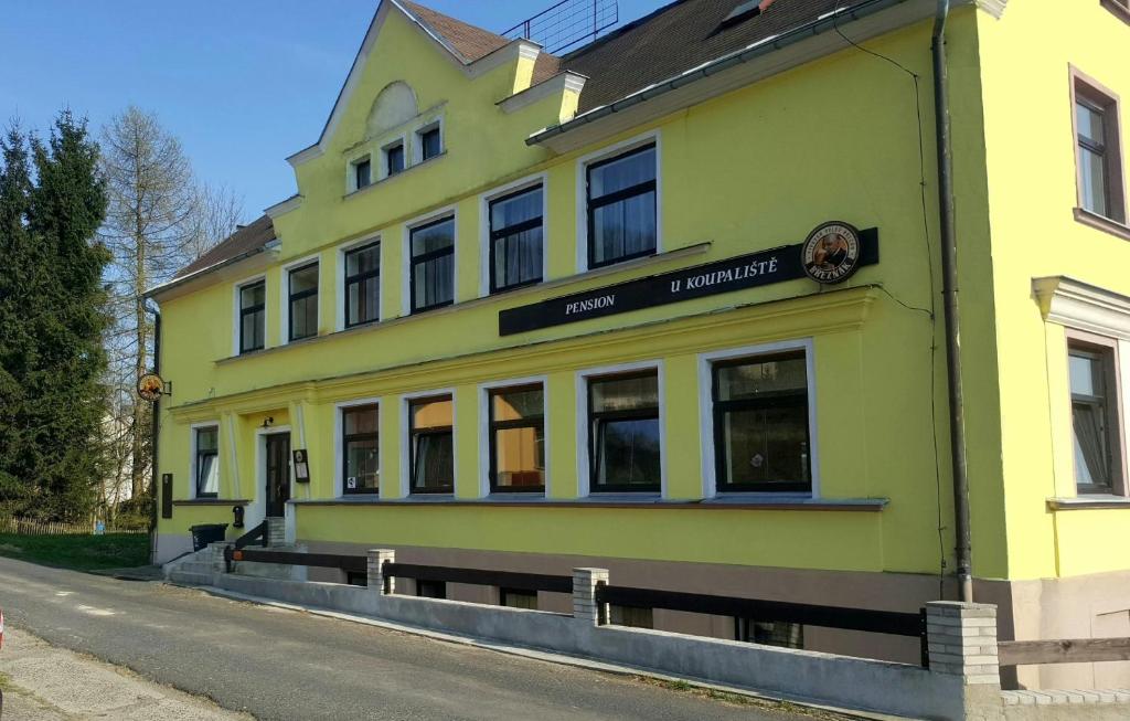 蒂萨Pension U Koupaliště的街道边的黄色建筑