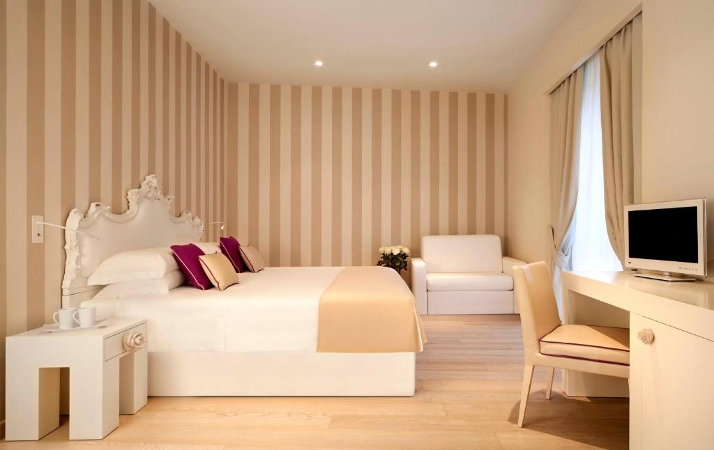 米兰米兰大教堂旅馆的一间卧室配有一张床、一张书桌和一台电视