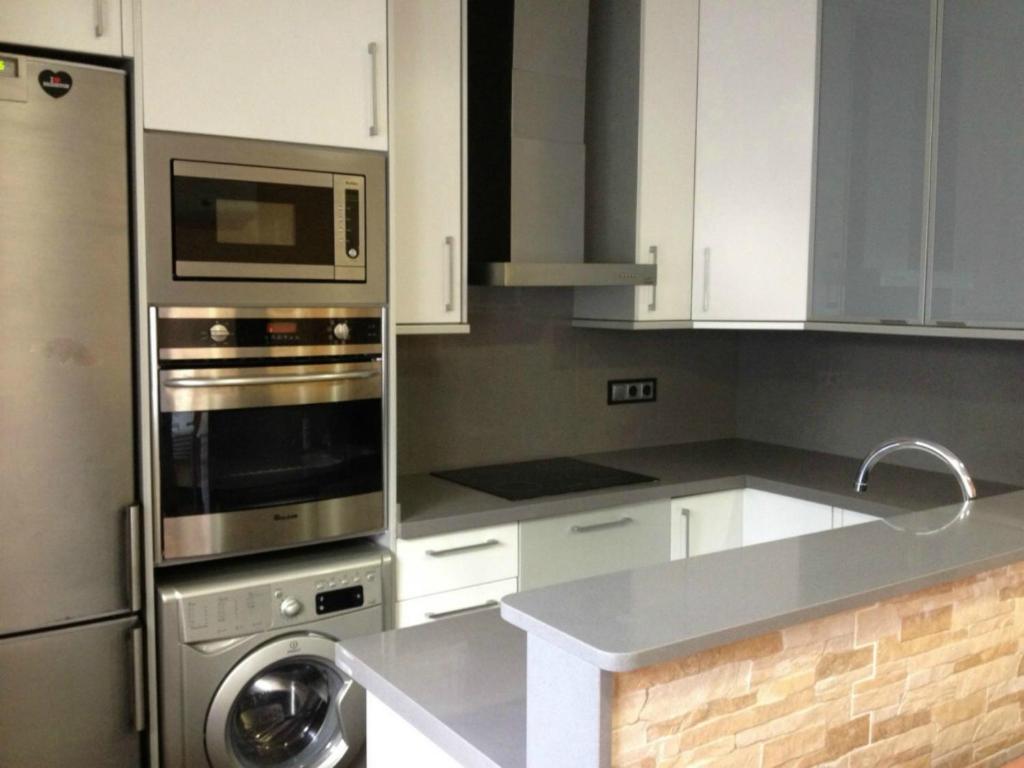甘迪亚Apartamento Cala Blanca的厨房配有白色橱柜和不锈钢用具