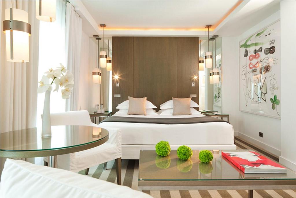 巴黎乐A酒店的一间卧室配有一张床和一张玻璃桌