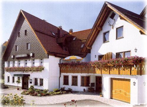 阿尔道夫格斯霍夫赫希酒店的一间白色的大房子,有棕色的屋顶
