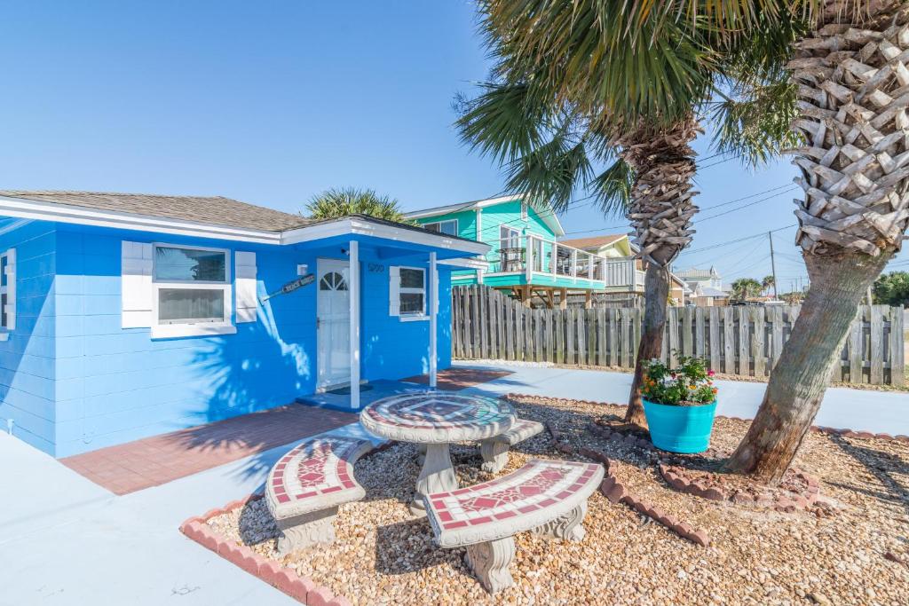 巴拿马城海滩Villa Paradise, Pet Friendly的两长椅和棕榈树的蓝色房子
