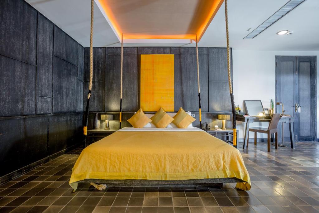 清迈阿兰塔拉河畔精品酒店- SHA Extra Plus的一间卧室配有一张带黄色床罩的大床
