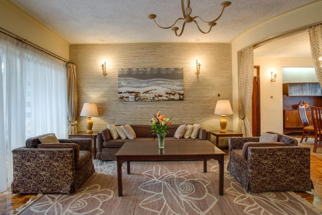 内罗毕含羞草庭院公寓的客厅配有沙发和桌子