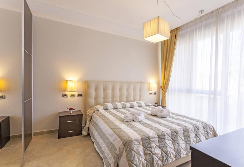 锡耶纳安吉赫尔酒店式公寓的一间卧室配有一张大床和毛巾