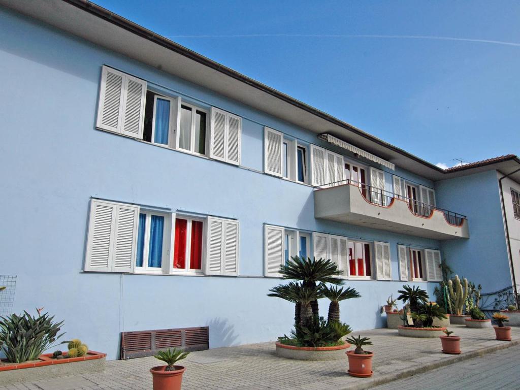 坎普码头Residence Il Pavone的蓝色的建筑,有白色的窗户和盆栽植物