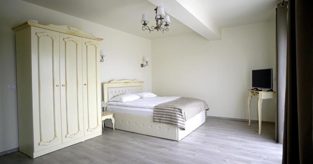 Remetea MarePensiunea Sofia的一间白色卧室,配有床和橱柜