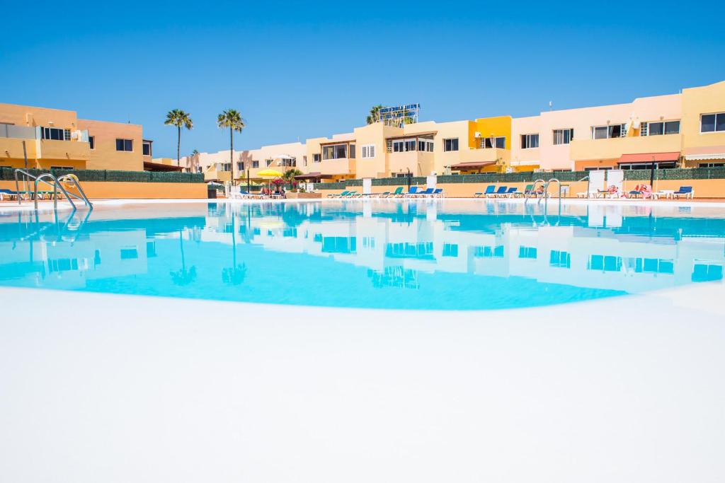 科拉雷侯Apartment Delfines Sand Corralejo By Holidays Home的一个空的游泳池,有建筑背景