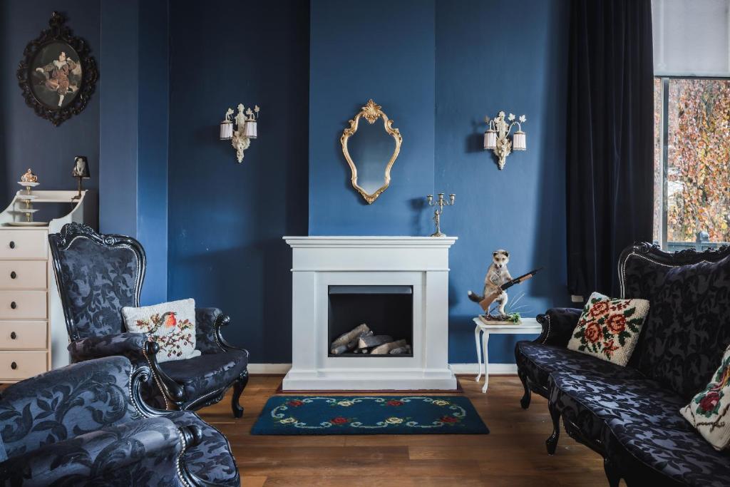 费尔普Villa Dalenstein的客厅设有蓝色的墙壁和壁炉。
