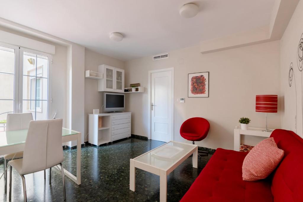 瓦伦西亚Apartamento valencia centro的客厅配有红色的沙发和桌子
