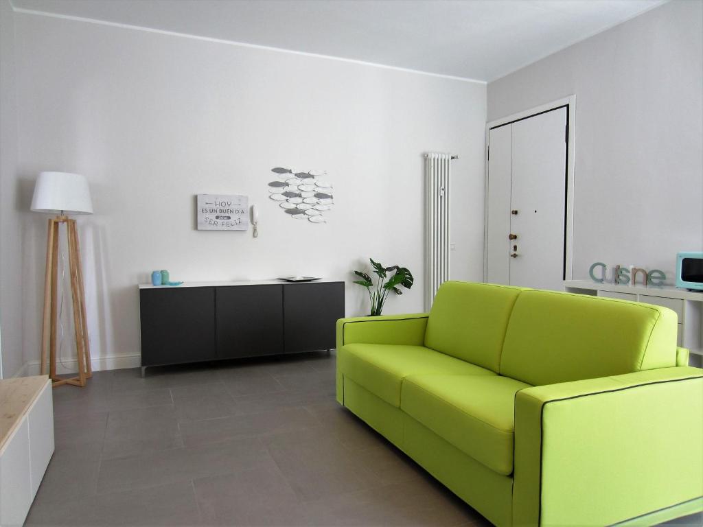 里米尼New & modern apartment on the sea的客厅配有绿色沙发和桌子